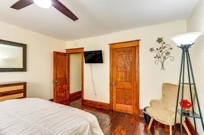 a bedroom with a bed and a chair at 2 Mi to Dtwn Harrisburg Escape with Furnished Deck! in Harrisburg