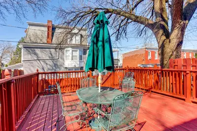 a table with a green umbrella on a deck at 2 Mi to Dtwn Harrisburg Escape with Furnished Deck! in Harrisburg