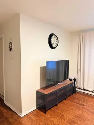 a living room with a tv and a clock on a wall at Independence Day Best Fireworks View July 6 in Clifton