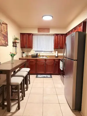 a kitchen with wooden cabinets and a stainless steel refrigerator at Independence Day Best Fireworks View July 6 in Clifton