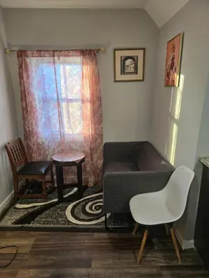 a room with a couch and two chairs and a window at favour family house in Newark