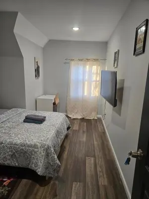 a bedroom with a bed and a television in it at favour family house in Newark
