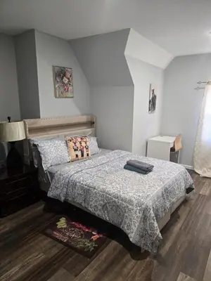 a bedroom with a bed with a comforter on it at favour family house in Newark