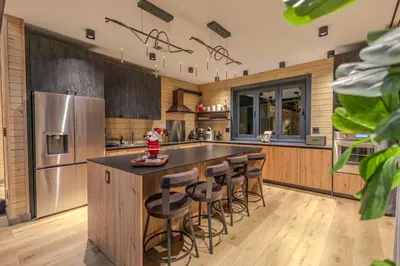 a kitchen with a large island with bar stools at Luxury 6BR Mansion - Lakefront, Sauna, Hot Tub in Scotrun