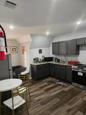 a kitchen with black cabinets and a table and chairs at Rose room 8 in Newark