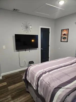 a bedroom with a bed and a flat screen tv at Rose room 8 in Newark