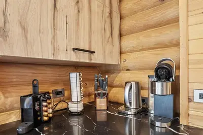 a kitchen with a counter top with a coffee maker at Log House Chalet, Volleyball field, Sauna, Hot Tub in Henryville