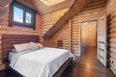 a bedroom with a bed in a log cabin at Log House Chalet, Volleyball field, Sauna, Hot Tub in Henryville