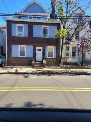 a brick house with a white door on a street at Beautiful Room 10D in Newark