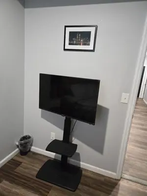 a flat screen tv sitting on a stand in a room at Beautiful Room 10D in Newark
