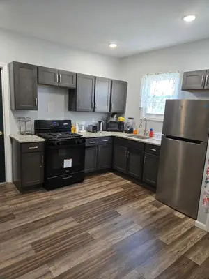 a kitchen with stainless steel appliances and wooden floors at Beautiful Room 10D in Newark