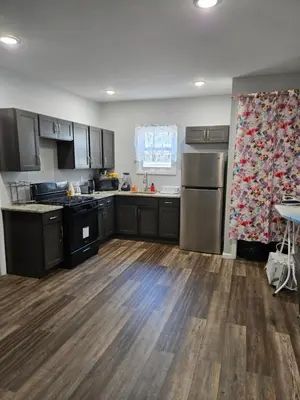 a kitchen with wooden floors and stainless steel appliances at Beautiful Room 10D in Newark
