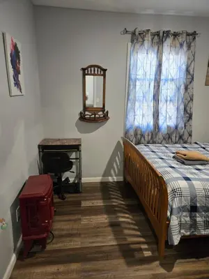 a bedroom with a bed and a mirror and a desk at Beautiful Room 10D in Newark