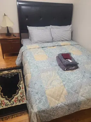 a bedroom with a bed with a blanket and a lamp at Grace Room 4 in Newark