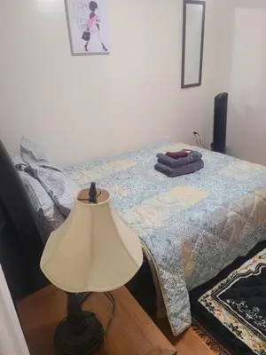 a bedroom with a bed with a lamp next to it at Grace Room 4 in Newark