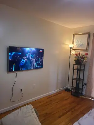 a living room with a flat screen tv on a wall at Grace Room 4 in Newark