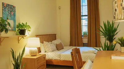 a bedroom with a bed and a couch and a window at Interfaith 21st Street in New York