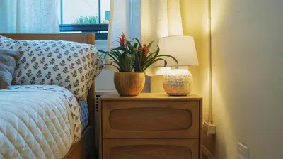 a bed with a lamp and a plant on a night stand at Interfaith 21st Street in New York