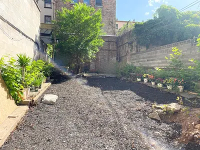 an empty garden with plants and a building at Interfaith 21st Street in New York