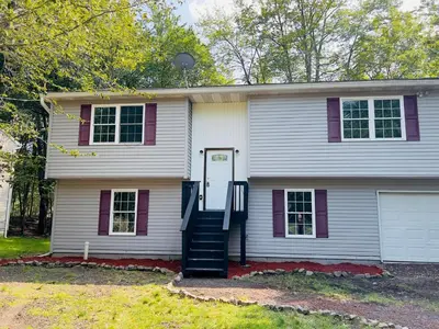 a white house with purple windows and a door at Newly renovated home, Fire pit, Games, Grill in Tobyhanna