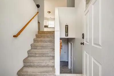 a staircase in a home with white walls and a white door at Newly renovated home, Fire pit, Games, Grill in Tobyhanna