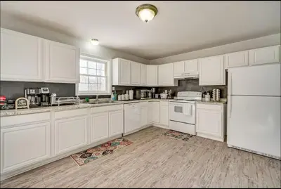 a kitchen with white cabinets and white appliances at Newly renovated home, Fire pit, Games, Grill in Tobyhanna
