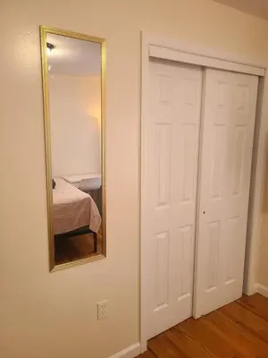 a bedroom with a mirror and a white door at Amazing family house in Newark