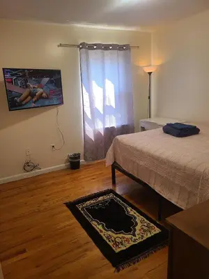 a bedroom with a bed and a tv on the wall at Amazing family house in Newark