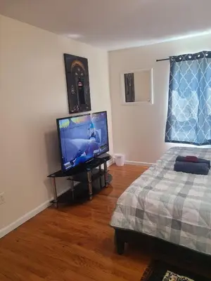 a bedroom with a flat screen tv and a bed at Amazing family house in Newark