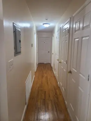 a hallway with white walls and a hard wood floor at Amazing family house in Newark