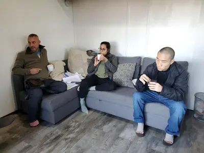 a group of three men sitting on a couch at Cozy Unique Tiny Cabin with Beautiful Views in Livingston Manor, New York in Livingston Manor