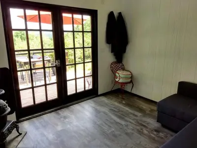 a living room with a door and a chair at Cozy Unique Tiny Cabin with Beautiful Views in Livingston Manor, New York in Livingston Manor