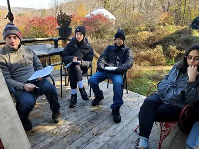 a group of people sitting on a bench at Cozy Unique Tiny Cabin with Beautiful Views in Livingston Manor, New York in Livingston Manor