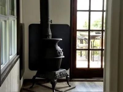 a stove in a room next to a window at Cozy Unique Tiny Cabin with Beautiful Views in Livingston Manor, New York in Livingston Manor