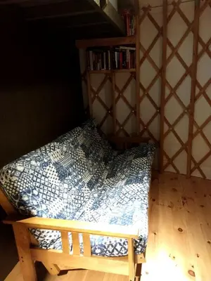 a bed in a room with a book shelf at Beautiful Yurt with Breathtaking Views in Livingston Manor, New York in Livingston Manor