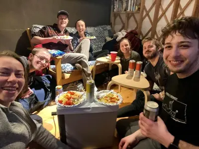 a group of people sitting in a room with food at Beautiful Yurt with Breathtaking Views in Livingston Manor, New York in Livingston Manor