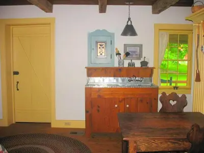 a room with a yellow door and a wooden table at Secluded and Rustic Cabin with a Private Deck near Reading, Pennsylvania in Robesonia