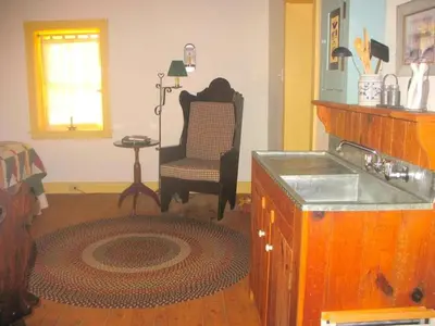 a living room with a chair and a table at Secluded and Rustic Cabin with a Private Deck near Reading, Pennsylvania in Robesonia