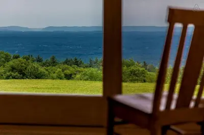 a chair sitting in front of a window with a view at Luxurious Modern Chalet Rental on Top of the Shawangunk Mountains in New York in Cragsmoor