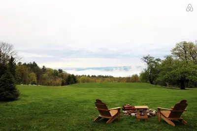 two chairs and a fire pit in a field at Luxurious Modern Chalet Rental on Top of the Shawangunk Mountains in New York in Cragsmoor