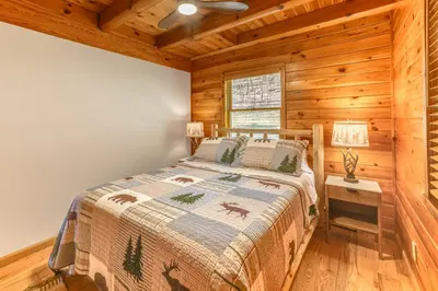 a bedroom with a bed in a log cabin at West Branch Delaware River Cozy Cabin Retreat! in Deposit