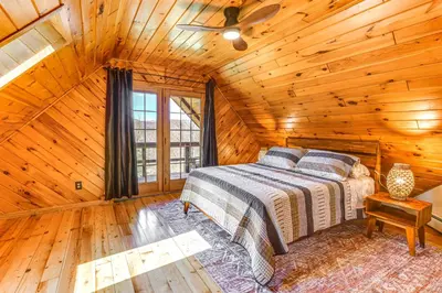 a bedroom with a bed in a log cabin at West Branch Delaware River Cozy Cabin Retreat! in Deposit