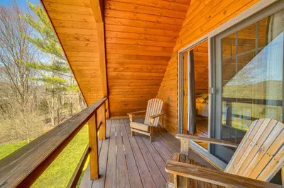 a porch of a cabin with two chairs and a window at West Branch Delaware River Cozy Cabin Retreat! in Deposit