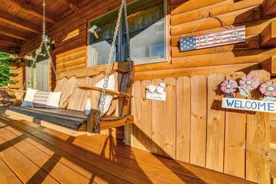 a porch of a wooden cabin with a porch swing at West Branch Delaware River Cozy Cabin Retreat! in Deposit