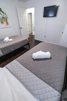 two beds in a hotel room with towels on them at Hudson Haven-Near NYC Transit in West New York