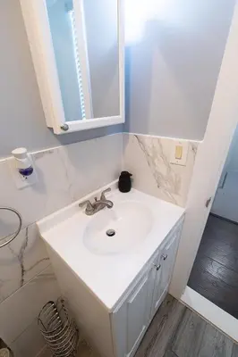 a bathroom with a white sink and a mirror at Hudson Haven-Near NYC Transit in West New York