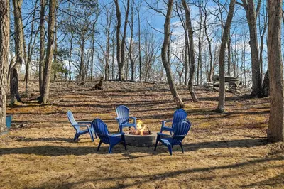 a group of chairs around a fire pit in the woods at Home in Bushkill Saw Creek Poconos area in Saw Creek