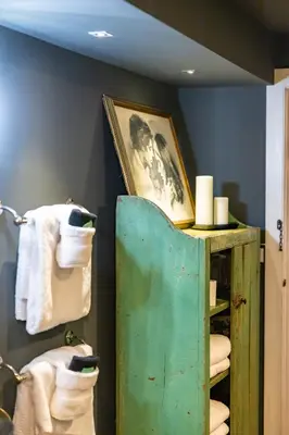 a bathroom with a green shelf with towels and a picture at John Quigley House - Downtown New Hope in New Hope