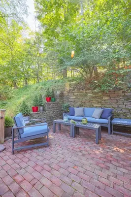 a patio with couches and tables and a brick wall at John Quigley House - Downtown New Hope in New Hope