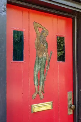 a painting of a man on a red door at John Quigley House - Downtown New Hope in New Hope
